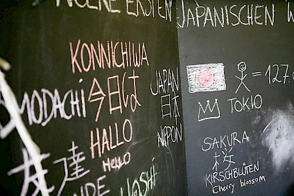 Aufnahme einer Tafel mit einem Exkurs in die japanischen Sprache. Hallo und Konnichiwa